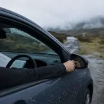 Location voiture ecosse : conducteur sur route des Highlands, gel sur le pare-brise