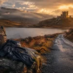 Quand visiter l'Écosse : route calme des Highlands au golden hour, loch brumeux et château